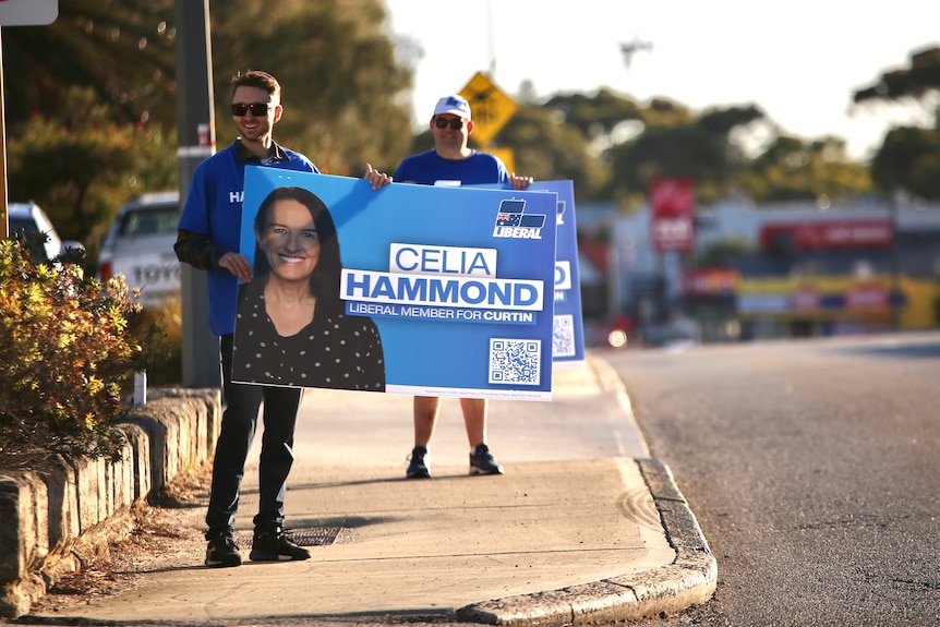 Volunteers for Celia Hammond holding up signs