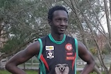 Lado Alphonse is dressed in his Cora Lynn Cobras team uniform as he stands in a garden.