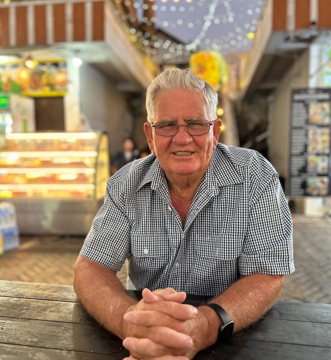 An elderly man smiling at the camera.