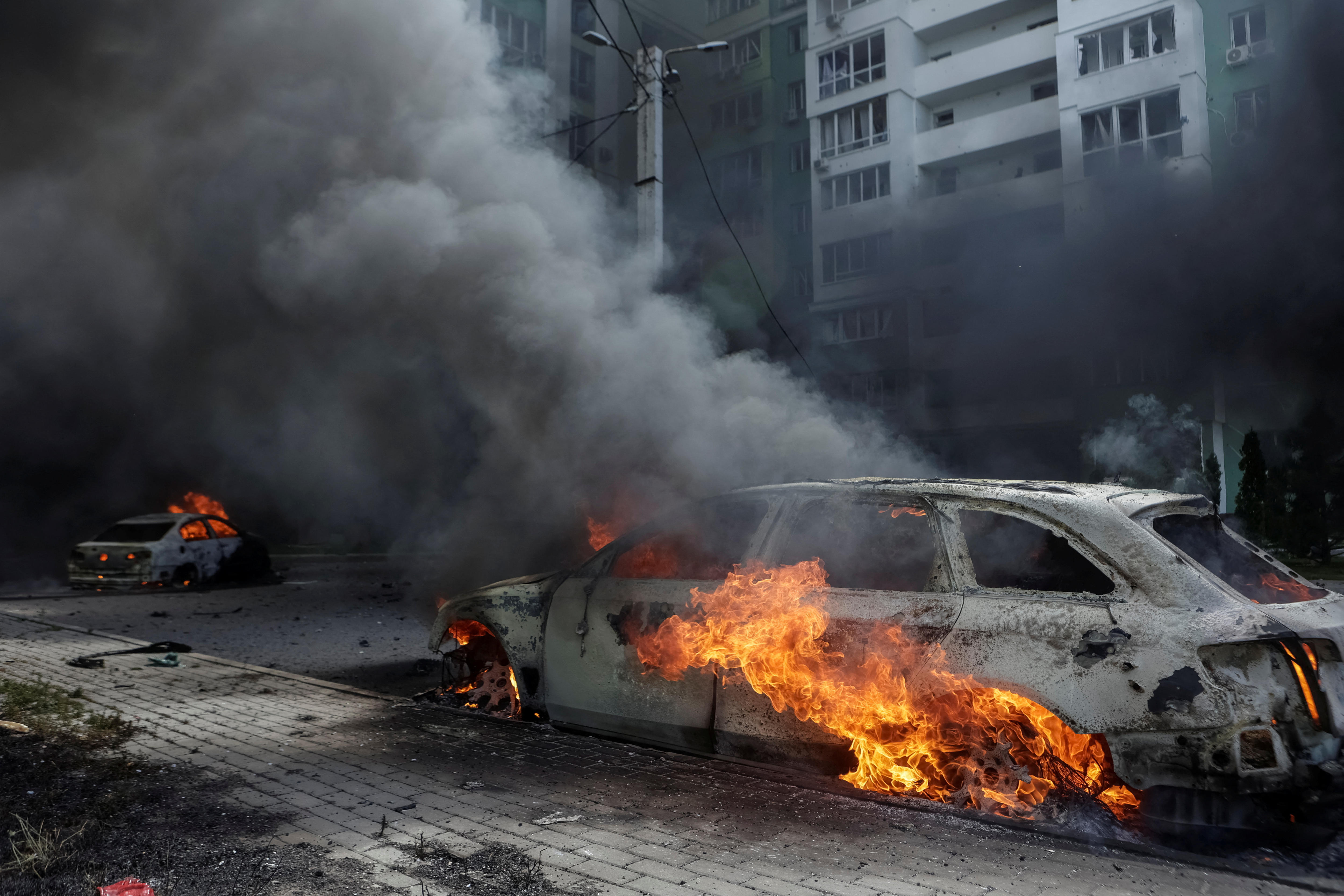 A car engulfed in flames with smoke billowing out the front