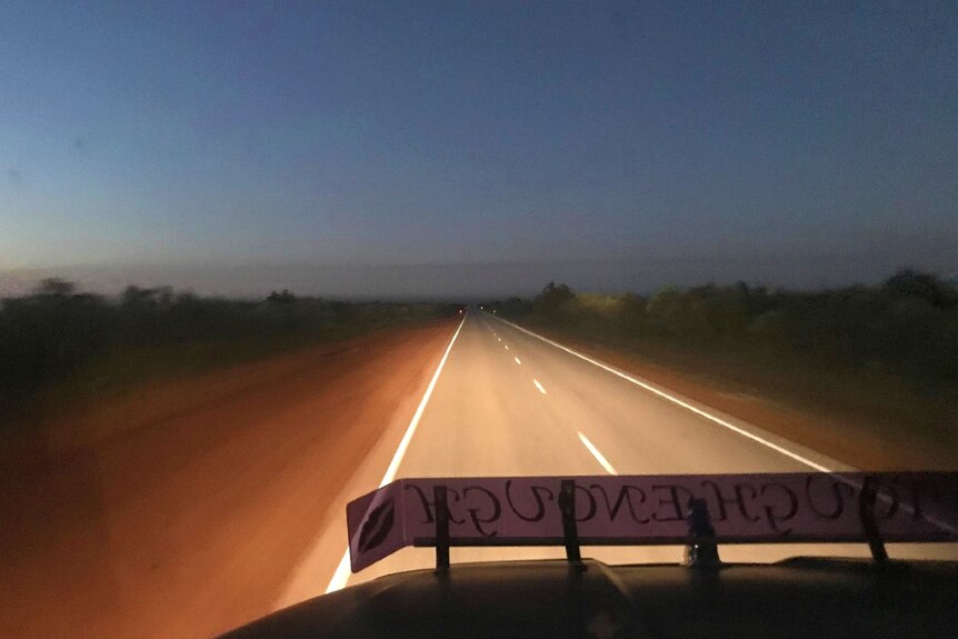 Headlights light up the highway at night