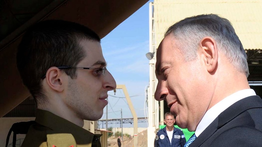 Israeli PM Benjamin Netanyahu (R) greets freed Israeli soldier Gilad Shalit at Tel Nof air base on October 18, 2011.