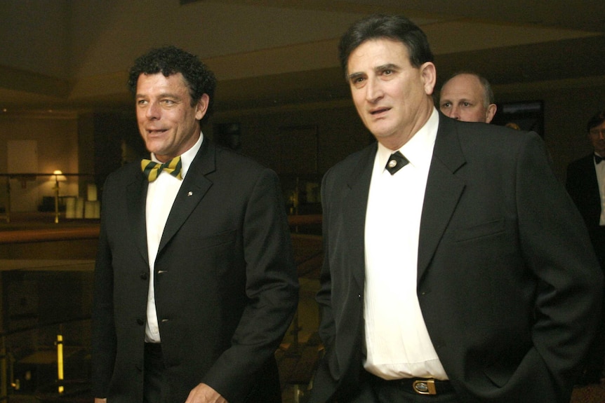 Two men in suits walking together.