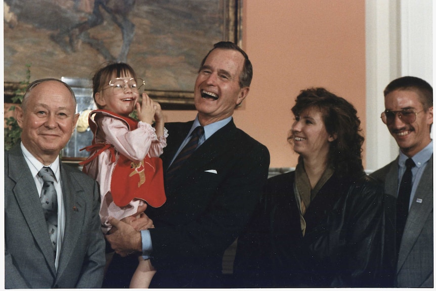 President George H W  Bush holds Jessica McClure