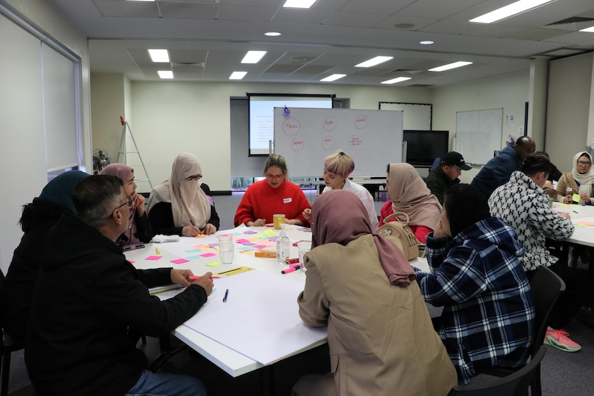 A group of people from CALD backgrounds participate in a workshop