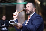 Sydney auctioneer Dion Moon holds the hammer before taking the winning bid.