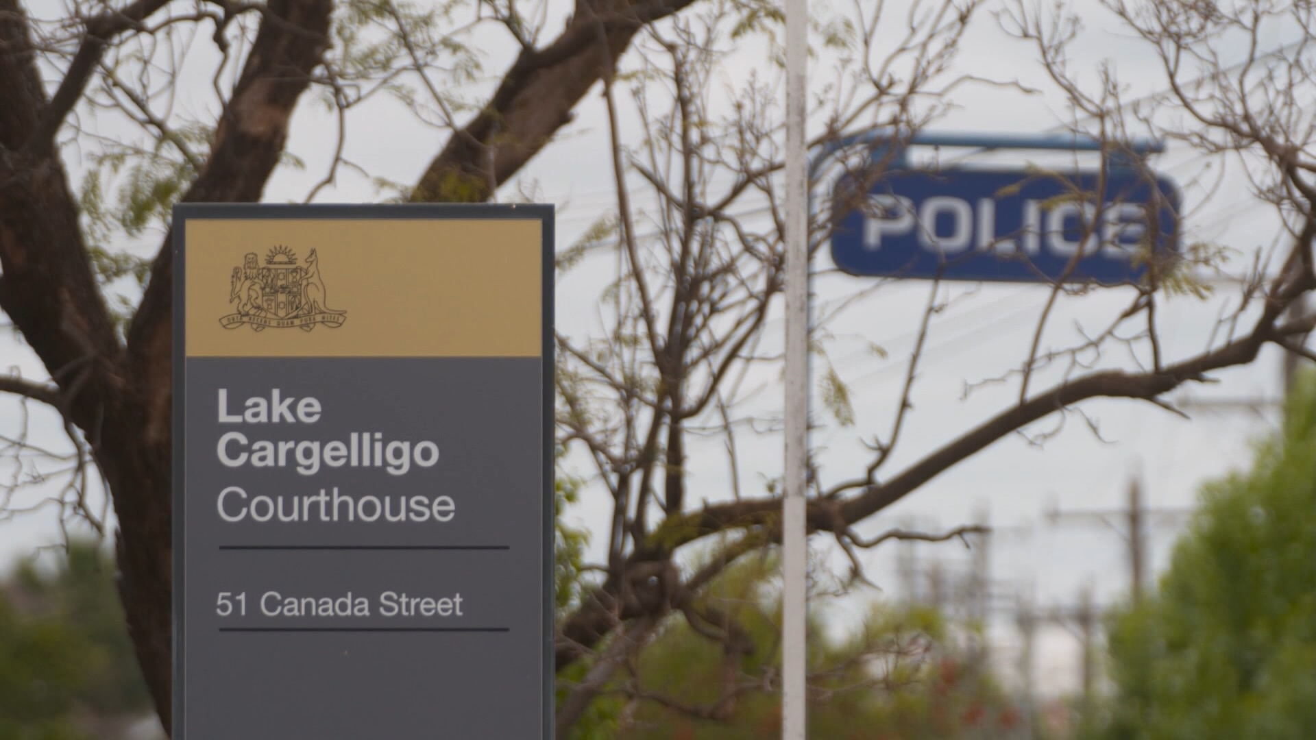 Uma placa azul da polícia e uma placa do tribunal do Lago Cargelligo.