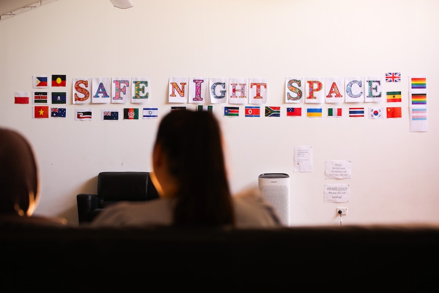 A wall with colourful lettering containing the name of the shelter and images of flags from various countries