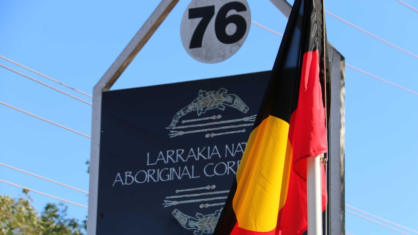 An aboriginal flag stands by the Larrakia Nation sign in Darwin.