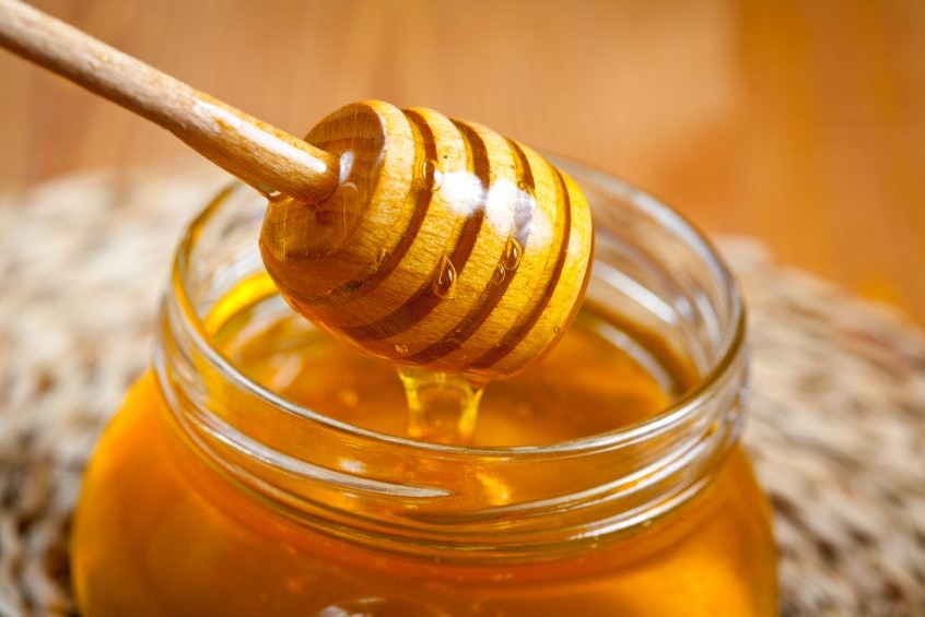 Honey dipper dripping with honey