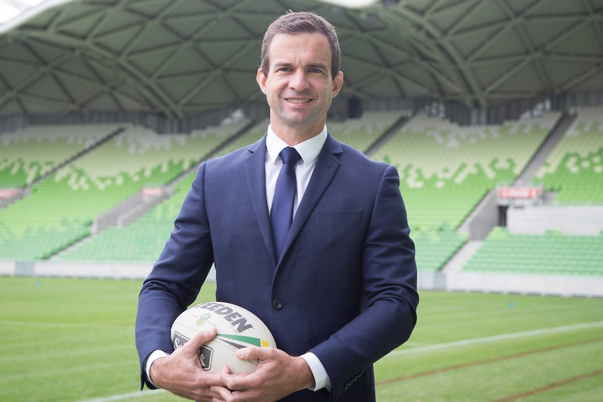 Sport CEO holding a football and looking at the camera