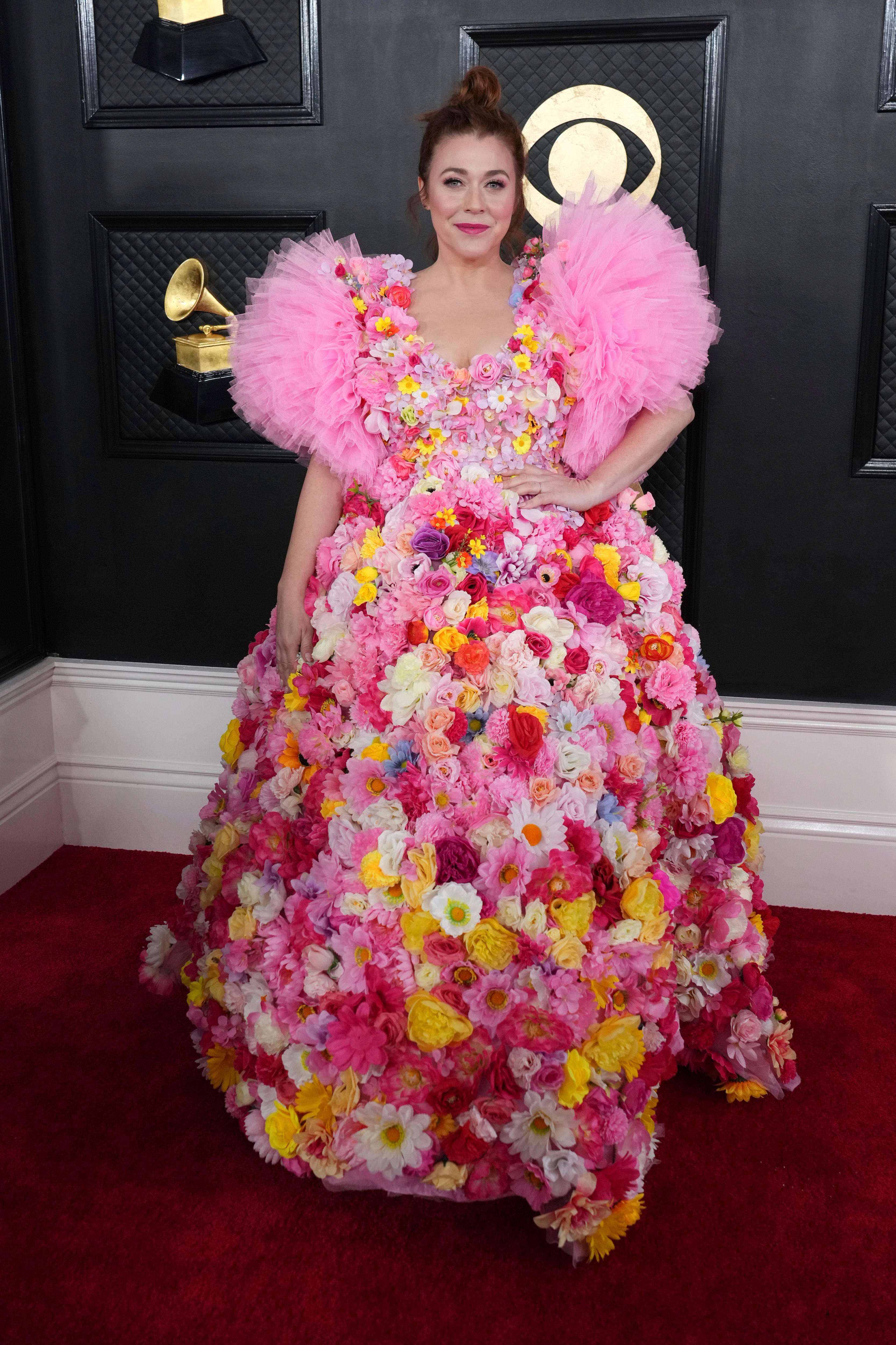 Alisha Gaddis wearing a big, puffy gown with bright pink tulle sleeves and hundreds of pink, yellow, white and purple flowers. 