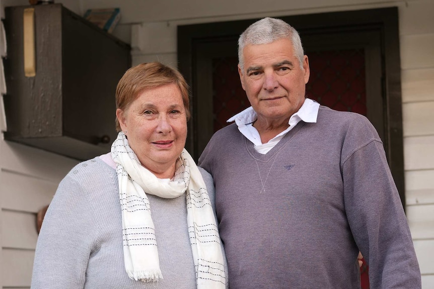 Kerryn and Stephen Longmuir stand at the front entrance of their home