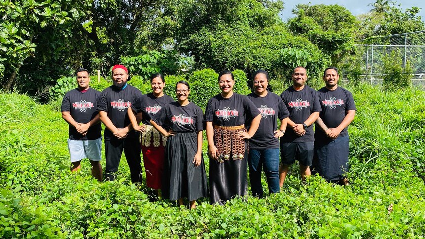 A group of young Tongans in a field of green, with matching t-shirts