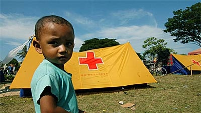 An Indonesian child stands in a makeshift camp for displaced survivors of the earthquake and tsunami