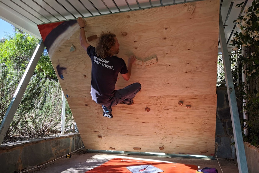 Boulderer climbs in driveway