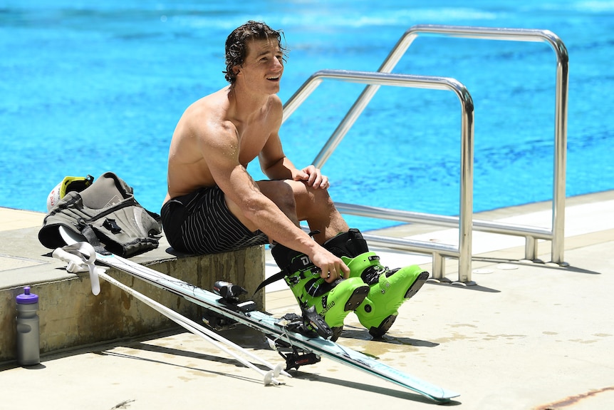 Australian skier Matt Graham sits beside a pool with his skis in Brisbane, January 12, 2022.