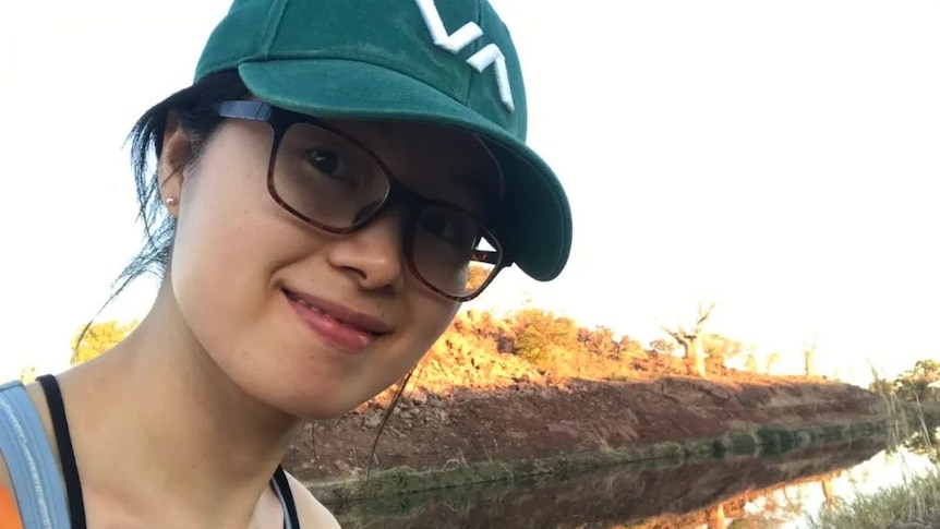 A selfie of Wenjing Wang wearing a green hat in the Australian outback.