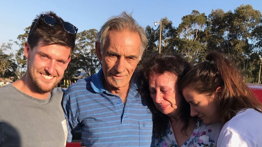 Mary and Dennis Gilbert are embraced by family after surviving the bushfire.
