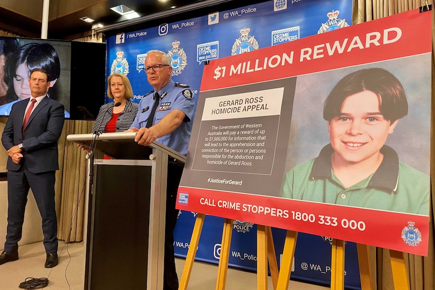 Police commissioner Chris Dawson stands at a podium in front of a billboard advertising the $1m reward.