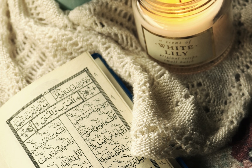 Open Qur'an next to a candle