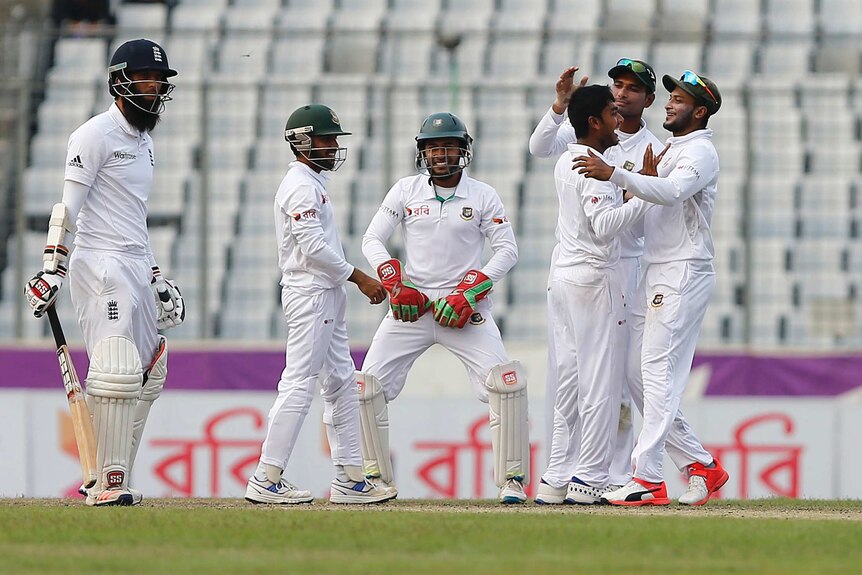 Bangladesh's Mehedi Hasan (3rd R) celebrates with team-mates after taking a wicket against England.