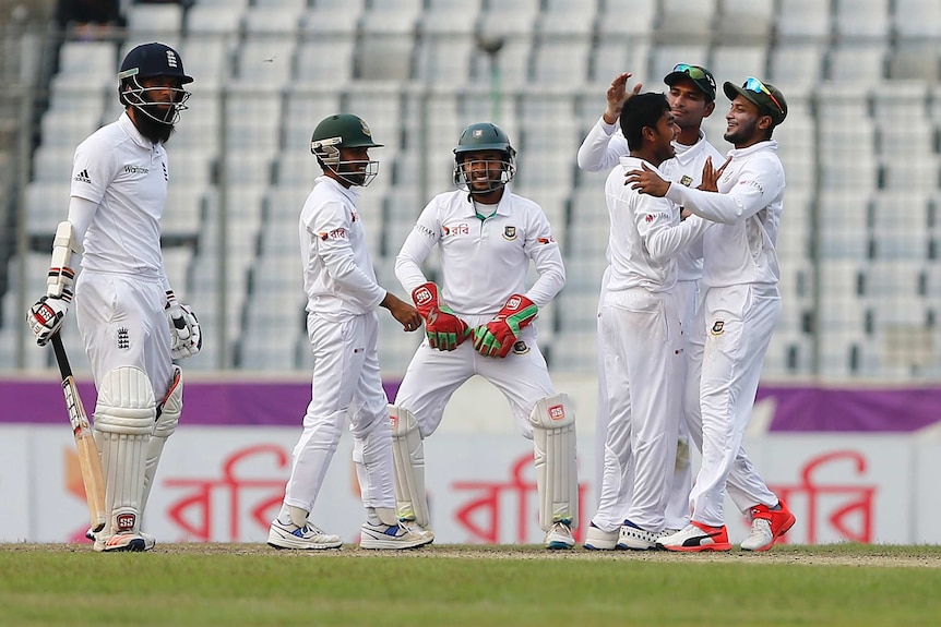 Bangladesh's Mehedi Hasan (3rd R) celebrates with team-mates after taking a wicket against England.