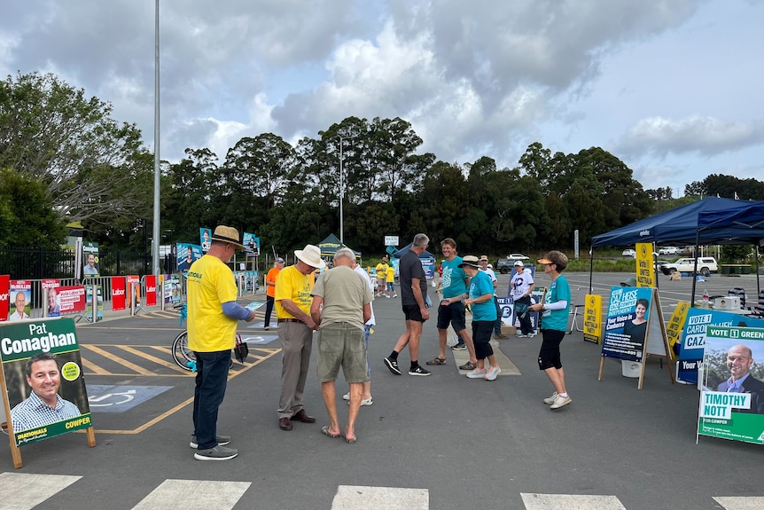 Voters are handed brochures outside a pre-polling centre in Coffs Harbour. 