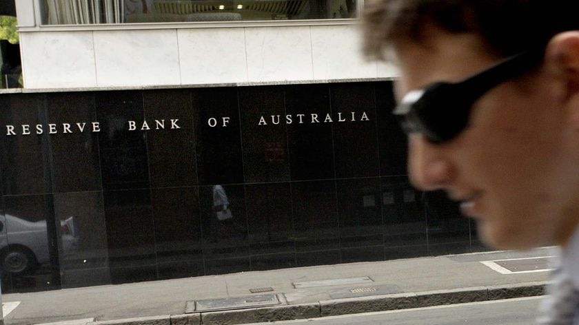 An office worker walks past the Reserve Bank of Australia building