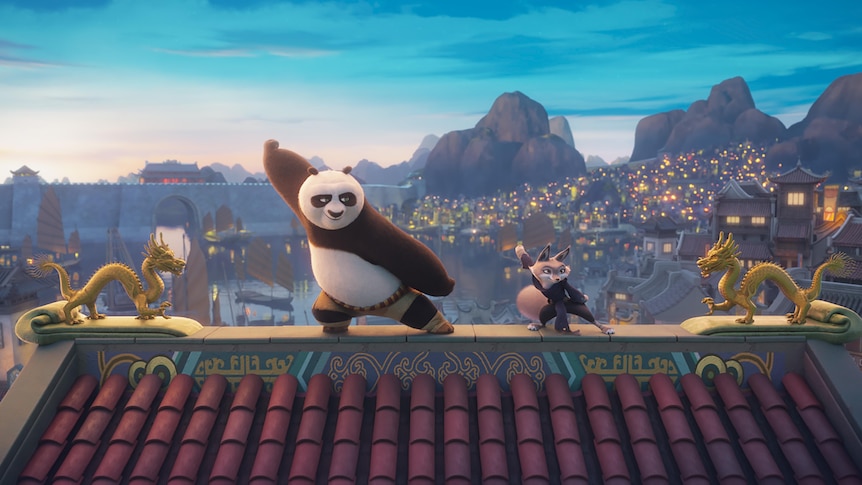 An animated panda and fox are on top of a temple roof, striking kung fu positions