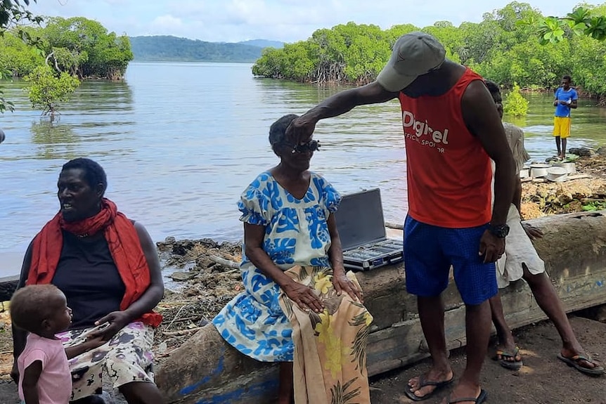 patients wait to be treated by a river