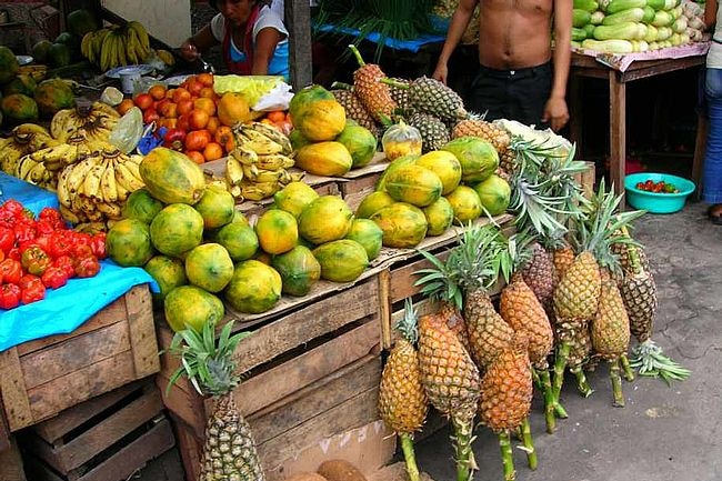 Papaya and pineapples at a market.