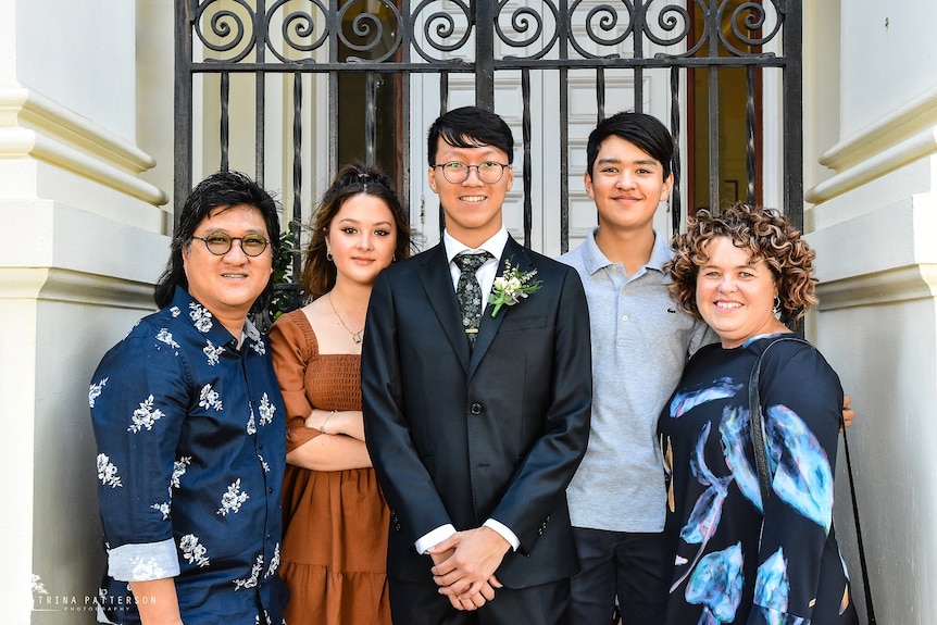 Cho family and Heetae standing in staircase, smiling at the camera.