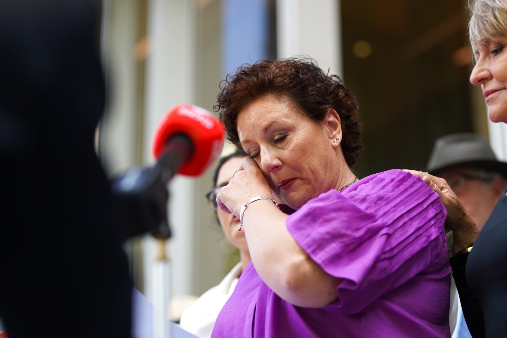 Kathleen Folbigg wearing a purple top  wipes her eye