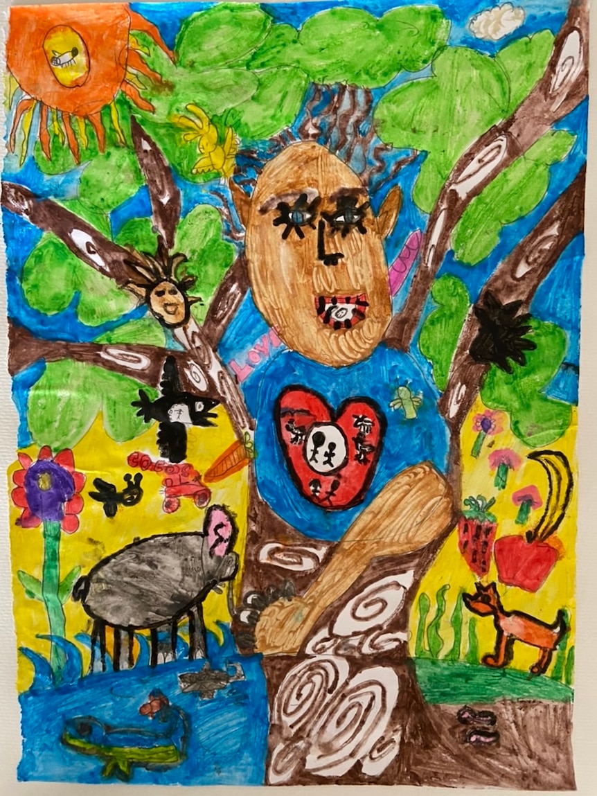 A child's drawing of a boy in a tree with the sun shining and animals all around.