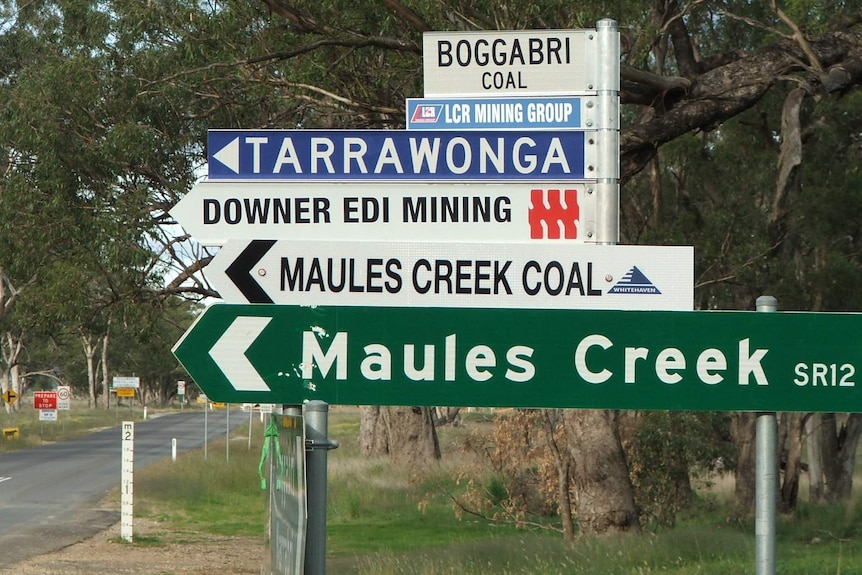 Road sign for Maules Creek and four other signs pointed to mine sites