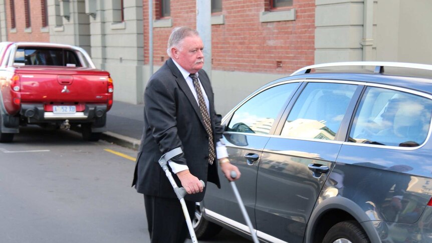 Tim Ellis arrives at court on crutches