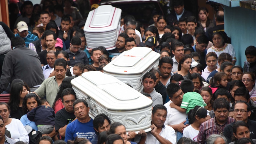 Relatives carry the coffins of three victims of a landslide near Guatemala City