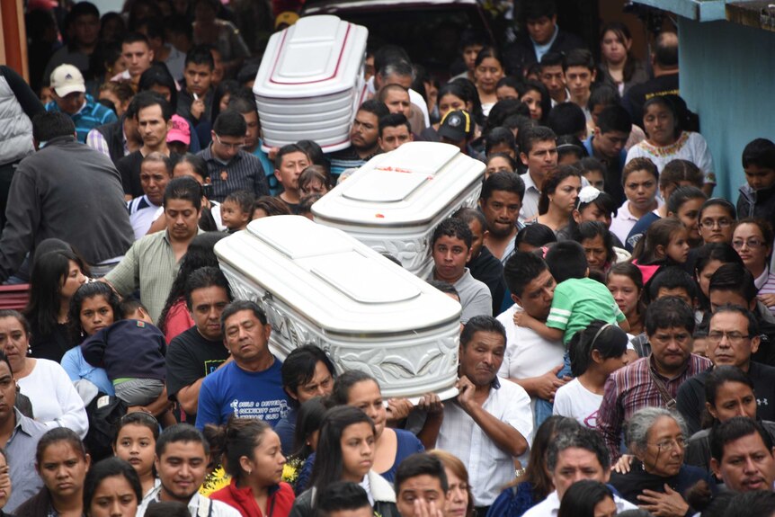 Relatives carry the coffins of three victims of a landslide near Guatemala City