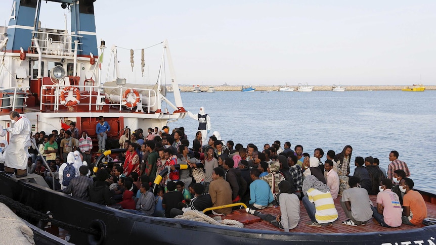 Migrants wait to disembark in the Sicilian harbour of Augusta, Italy, May 30, 2015.