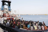 Migrants wait to disembark in the Sicilian harbour of Augusta
