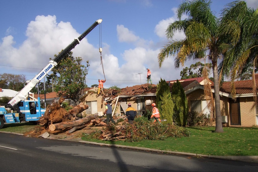 Emergency service workers at a Palmyra house which has been badly damaged by a tornado.