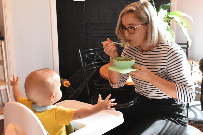 Chantelle Dagasso feeding her youngest son Max who is sitting in a highchair.