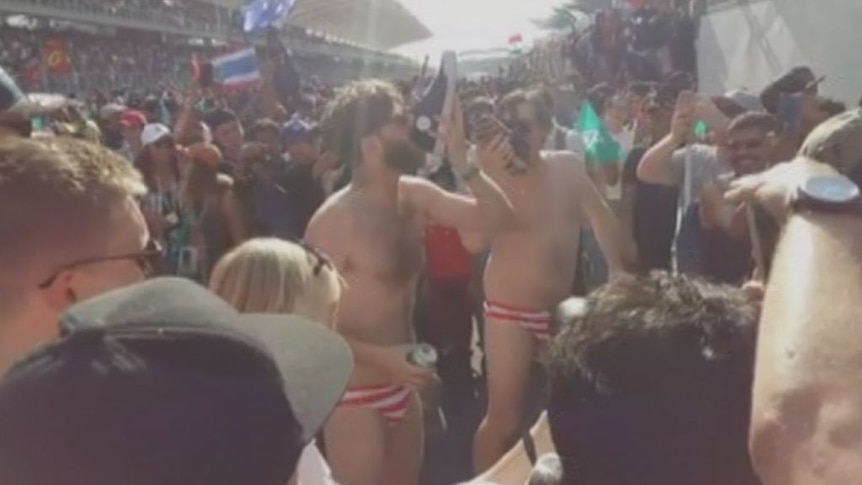 The Australian men are filmed wearing Malaysian flag swimmers and drinking from shoes