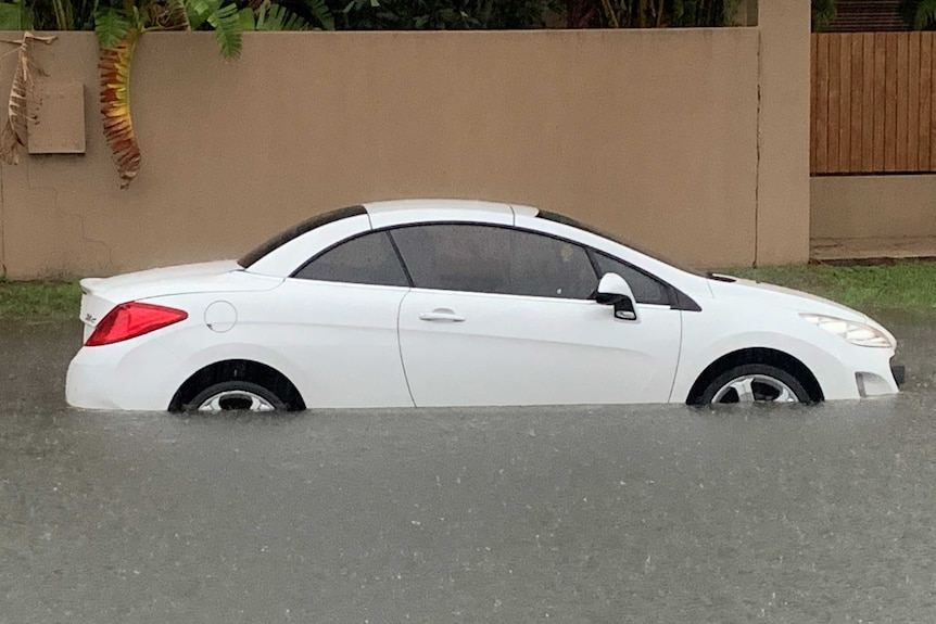 A white car in water up to its wheels in Broadbeach Waters
