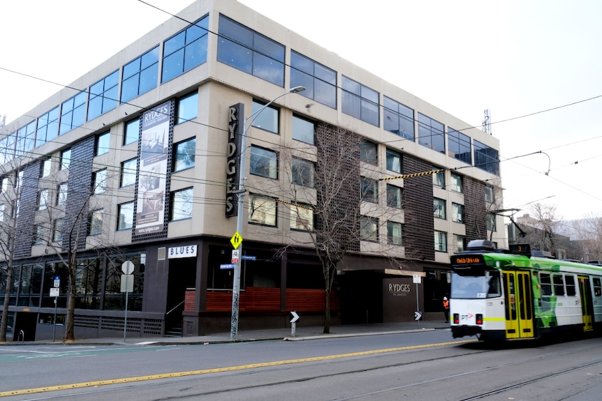 A tram glides past the Rydges hotel on a grey Melbourne day.