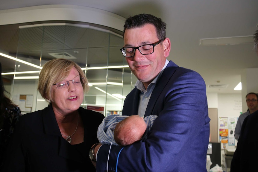 Daniel Andrews and Lisa Neville hold a baby in Geelong.
