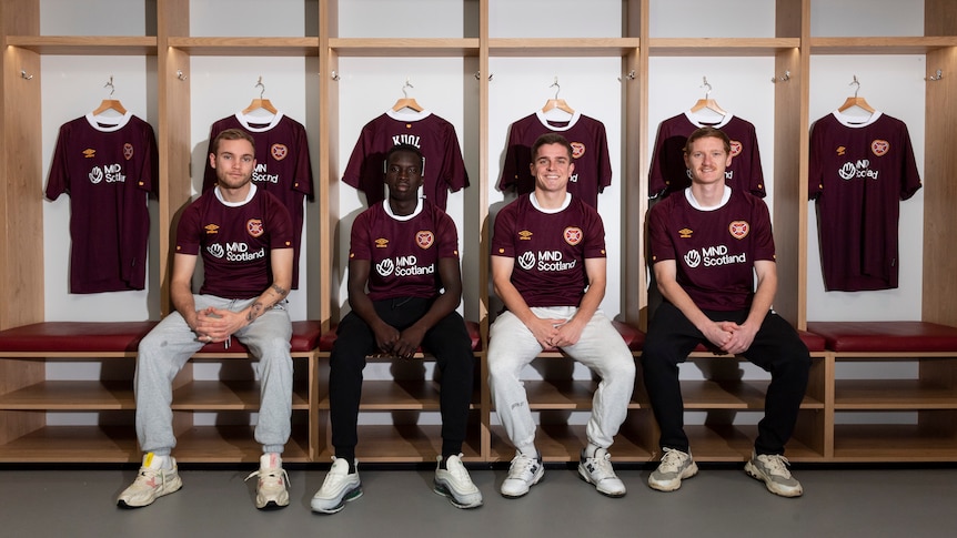 Nathaniel Atkinson, Garang Kuol, Cammy Devlin and Kye Rowles sit side by side in the Hearts locker room.