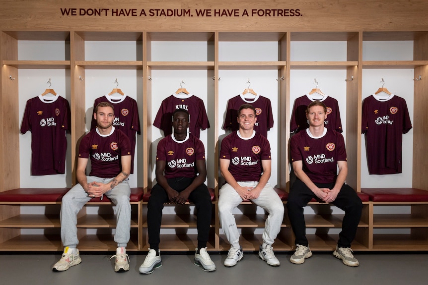 Nathaniel Atkinson, Garang Kuol, Cammy Devlin and Kye Rowles sit side by side in the Hearts locker room.