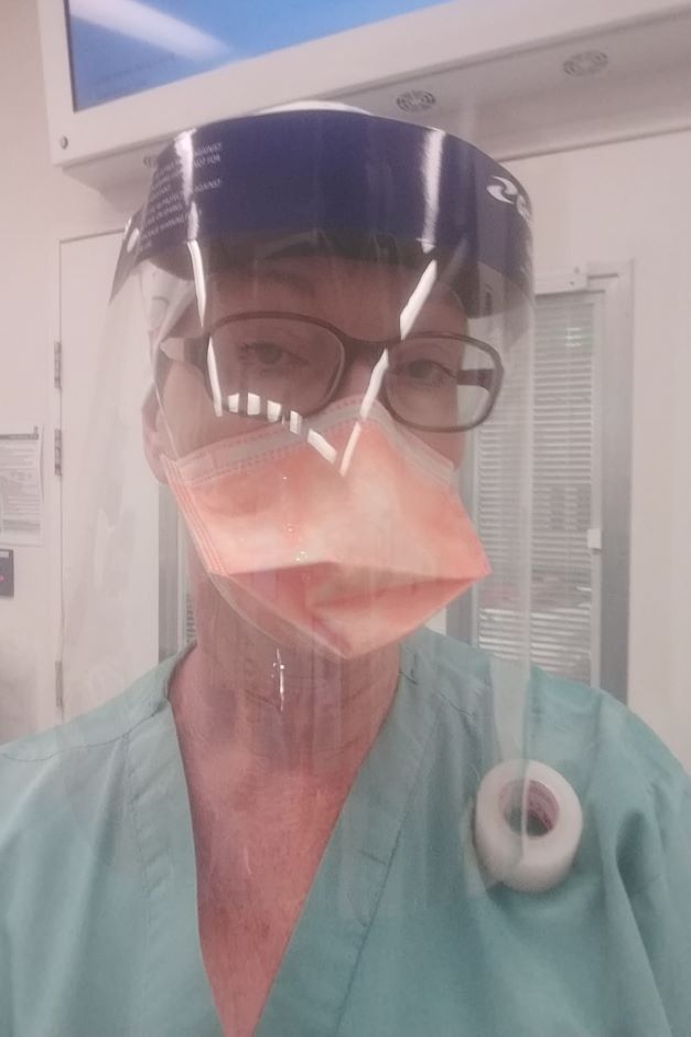 Woman wearing glasses, face shield and mask and hospital uniform